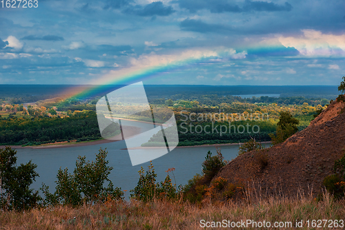 Image of Rainbow with clouds over a river valley