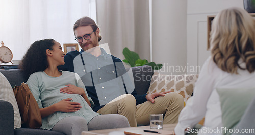 Image of Pregnancy, smile and couple in therapy with a therapist for support, help and planning for baby in an office. Consulting, happy and man and woman talking with a psychologist about being pregnant