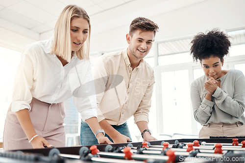 Image of Business people, foosball table and competition in office for team building, motivation and teamwork in startup company. Group diversity employees playing creative soccer games for fun collaboration