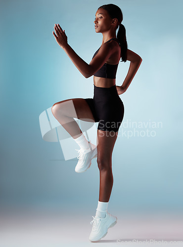 Image of Sports, exercise and woman runner in studio with balance, form and motivation. Fitness, health and black woman from Jamaica running on blue background. Healthy girl cardio training for marathon race.