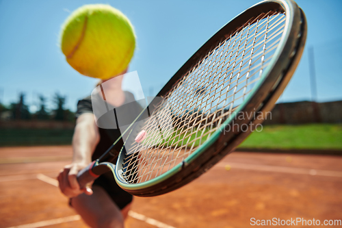 Image of Close up photo of a young girl showing professional tennis skills in a competitive match on a sunny day, surrounded by the modern aesthetics of a tennis court.