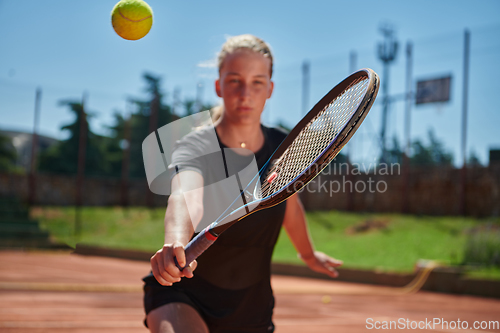 Image of A young girl showing professional tennis skills in a competitive match on a sunny day, surrounded by the modern aesthetics of a tennis court.