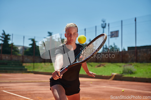 Image of A young girl showing professional tennis skills in a competitive match on a sunny day, surrounded by the modern aesthetics of a tennis court.