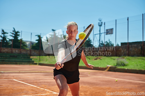 Image of A young girl showing professional tennis skills in a competitive match on a sunny day, surrounded by the modern aesthetics of a tennis court.