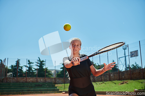 Image of A young girl showing professional tennis skills in a competitive match on a sunny day, surrounded by the modern aesthetics of a tennis court.