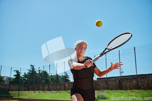 Image of A young girl showing professional tennis skills in a competitive match on a sunny day, surrounded by the modern aesthetics of a tennis court.