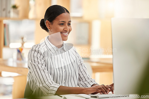 Image of Happy business woman worker on computer working in the office at a corporate company. Smile, planning and market online research female entrepreneur working on a desktop in her workplace while typing