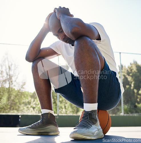 Image of Depression, sport and man on basketball court for fitness outdoors. Stressed black athlete, mental health and tired after wellness workout or exercise training burnout in sports park with ball