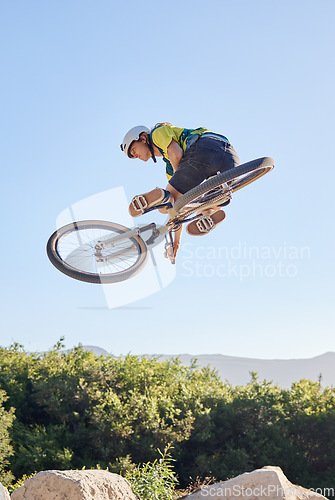 Image of Bike, extreme sport and outdoor fitness, man does dangerous stunt, sports motivation and training in nature. Exercise, athlete with mountain bike, risk and active with energy and jump over rocks.