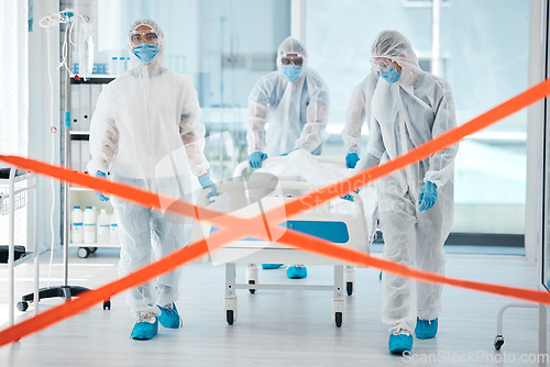 Image of Covid quarantine, medical team and patient in bed, moving to isolation or test area with warning tape in hospital. PPE suits, safety and healthcare, group of doctors or nurses move body on stretcher.