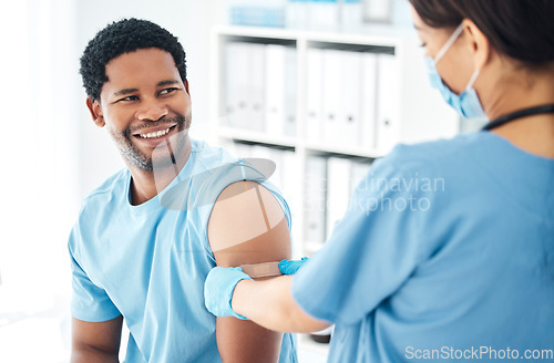 Image of Doctor, vaccine and covid bandaid on arm of man patient for healthcare, medical vaccination and consultation. Hospital nurse with a plaster for an injury, virus or safety while sick and face mask