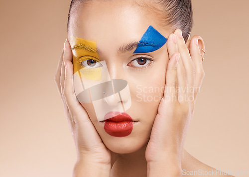 Image of Beauty, clown and portrait of a woman with makeup, face paint or facial art for self expression in studio. Cosmetic, creative and model with fun circus cosmetics on skin isolated by peach background.