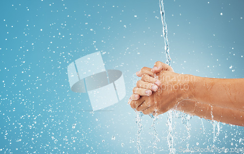 Image of Water splash, cleaning hands and hygiene on blue background, advertising or product placement space. Health, skincare and safety from germs or bacteria, man washing hand in water in studio background