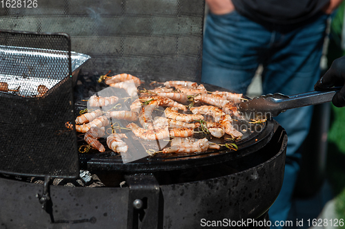 Image of A professional cook prepares shrimps