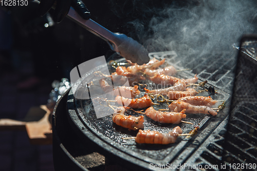 Image of A professional cook prepares shrimps