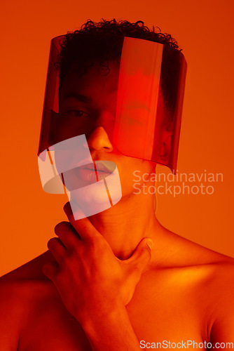 Image of Orange, futuristic and man with a neon visor for cyberpunk, creative style and art against a studio background. Digital, fashion and face portrait of a model with a designer product for future