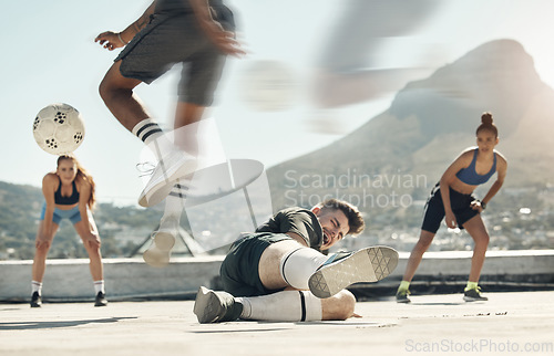 Image of Soccer, sports and tackle with a man player sliding an opponent during a game or match on a city rooftop outdoor. Football, fitness and exercise with a soccer player slide tacking for competition