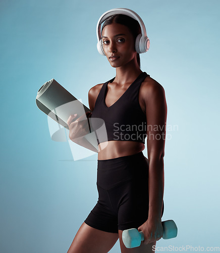 Image of Headphones, fitness and exercise woman in studio with dumbbells and yoga or cardio gear for workout wellness, exercise or training fashion portrait. Black woman with sports music and health mock up