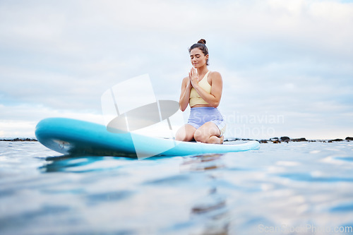 Image of Yoga meditation, ocean and surfer woman meditating for health wellness, peace or freedom on sea water. Surfboard pilates, prayer and zen girl meditate for beach fitness, aura or chakra energy healing
