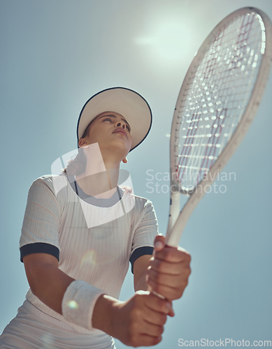 Image of Professional tennis player, fitness and woman athlete playing sports, match and games with tennis racket on blue sky lens flare. Below of tennis girl with focus mindset in training to win competition