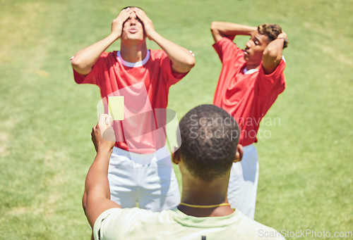 Image of Sports, soccer and referee with yellow card standing on field with upset, angry and mad soccer players. Foul, mistake and athlete getting warning for rules violation in game or match on soccer field