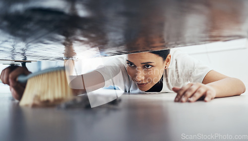 Image of Woman, hand broom or sweeping dust in house, home or hotel bedroom in housekeeping cleaning, cleaner service or hygiene maintenance. Brush, dirty or messy floor spring cleaning under hospitality sofa