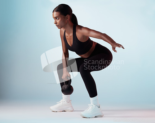 Image of Black woman, kettlebell and exercise for wellness, focus or motivation for health, fitness and studio background. Female trainer, training and athlete being healthy for workout, strong and sportswear