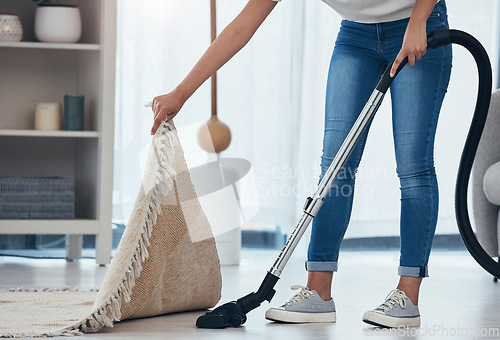 Image of Woman, cleaning and doing house work with vacuum machine appliance for living room carpet to clean dirt or dust. Feet of female cleaner or housewife doing housekeeping on lounge floor for hygiene