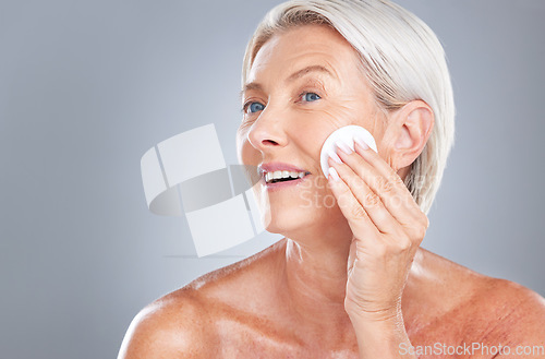Image of Cotton pad, skincare and senior woman in studio for beauty, cleaning and grooming on grey background mockup. Face, cotton and elderly model relax with product, cleanser and hygiene, skin and wellness