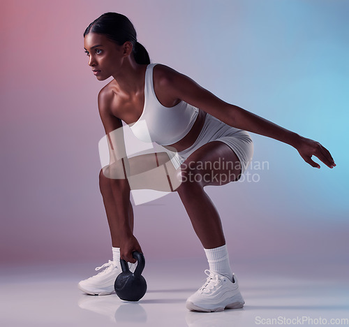 Image of Fitness, exercise and woman with a kettlebell in studio strength training and burning calories in a full body exercise. Energy, workout and healthy girl swings a heavy weight for strong arms and legs