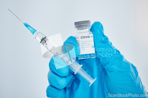 Image of Doctor, hand and covid vaccine, syringe and medicine for health, safety and protection from virus against mockup space background. Medical expert, glove and covid 19 treatment for pandemic healthcare