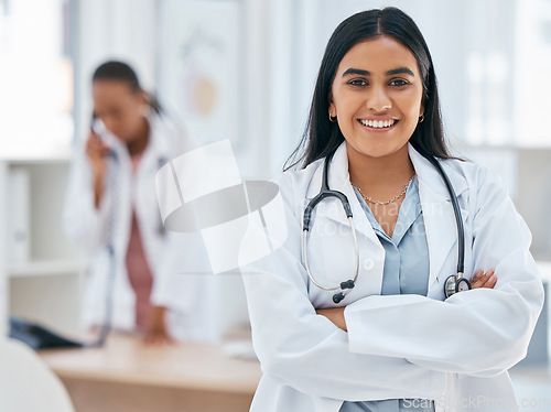 Image of Indian woman, doctor and arms crossed in hospital with trust, wellness goals or healthcare motivation. Portrait, smile or happy medical worker, life insurance employee or friendly consulting surgeon