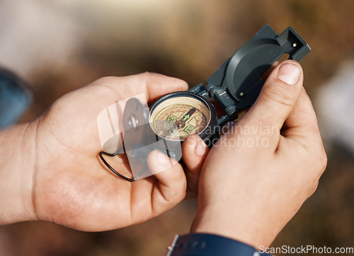 Image of Hands, compass and travel for direction, map or location in adventure, hike or navigation in the outdoors. Hand of traveler holding tracker for scope, tourism or hiking in exploration for journey