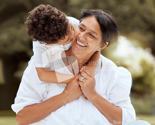 Image of Hug, kiss and grandmother with a child in a park with love, freedom and care for family. Happy, smile and senior woman hugging a kid with affection, gratitude and bonding in nature, garden or field