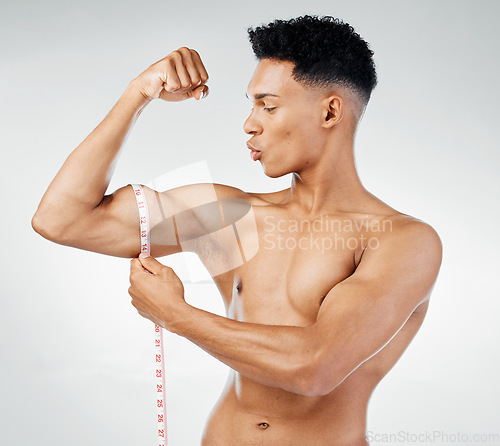 Image of Fitness, biceps and man with measuring tape on arm, check muscle growth and development in training exercise. Workout, gym and happy healthy bodybuilder measuring bicep muscles, health and wellness.