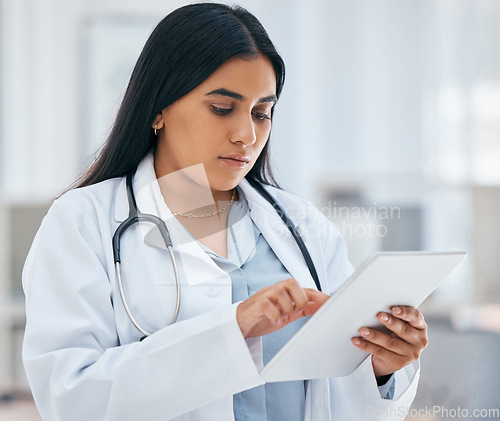 Image of Health, healthcare and doctor on tablet in hospital working on patient records, researching medicine and planning schedule. Medical professional, female and worker from India on tech browsing web.
