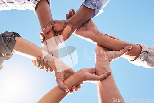 Image of Hands, community and link team together global community of cooperation on blue sky. Group diversity in volunteer partnership, social solidarity or collaboration friends of circle arms and teamwork