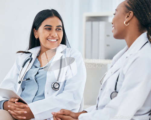 Image of Diversity, healthcare and doctors talking in hospital, having casual conversation, discussion and chatting. Medical workers, friends and Indian woman with black woman chat, talk and laugh in clinic