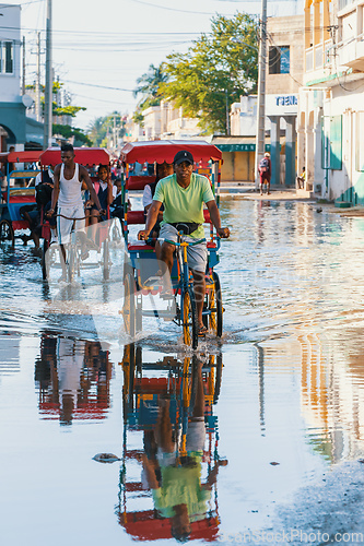 Image of Traditional rickshaw bicycle with Malagasy people on the street of Toliara, one of the ways to earn money. Everyday life on the street of Madagascar.