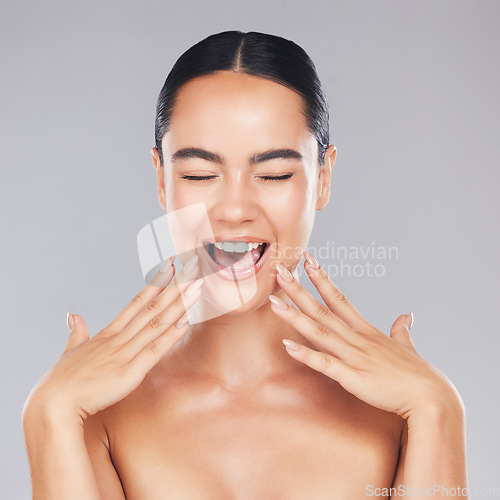 Image of Woman, smile and hands in beauty for skincare, cosmetics or makeup treatment against a grey studio background. Excited happy female smiling with teeth in satisfaction for perfect luxury cosmetic care