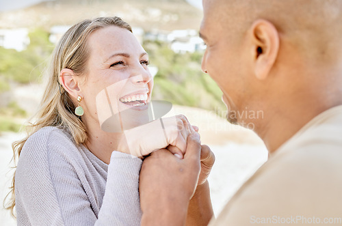 Image of Beach, holding hands and man propose to woman on holiday by sea, happy and smiling together. Affection, romance and multicultural couple by ocean, enjoying vacation and bonding on weekend in summer