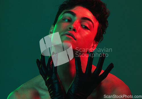 Image of Art, neon lights and creative portrait of man with leather gloves, serious face and self expression. Futuristic cyberpunk fashion, topless male model and artistic beauty on green studio background.