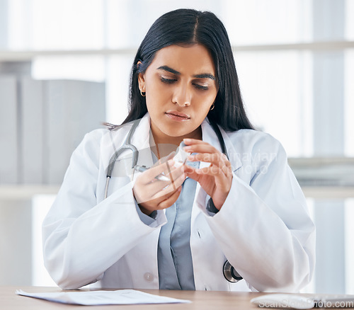 Image of Woman with medication prescription, health and doctor in hospital office, focus and reading instruction label. Healthcare, stethoscope and medical paperwork on desk, vaccine or cold and flu medicine.