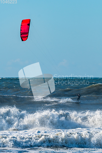 Image of Kitesurfer riding ocean waves