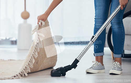 Image of Vacuum, floor and woman cleaning under a carpet in the living room of a house. Housekeeping, service and cleaner vacuuming in the lounge with a rug or mat for care and disinfection of dirt in home