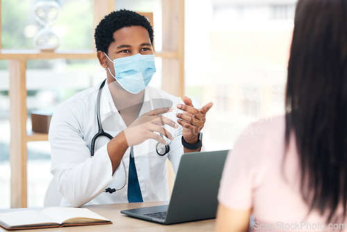 Image of Covid, laptop and doctor consulting patient for vaccine advice, healthcare corona virus results and check exam report in a hospital office. Covid 19 medical black man expert talking in consultation