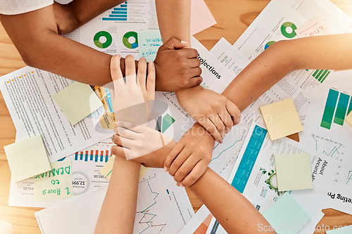 Image of Collaboration, support and team with joined hands with paperwork to plan a marketing project. Unity, diversity and business people working with documents for statistics, graphs and data in the office