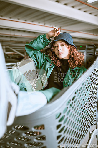 Image of Fashion, parking lot and shopping cart portrait of woman student relaxing with edgy, trendy and carefree style at mall. City, young and urban fashionista girl in Mexico resting in customer trolley.