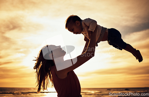 Image of Family, silhouette and beach sunset with mother and baby against golden sky with love, care and support while on vacation in summer. Woman and child happy by sea for travel, adventure and freedom