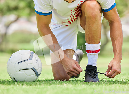 Image of Sports, soccer and man tie shoe on field, ready for game, match and outdoor training. Fitness, exercise and soccer player tying shoelace on sneaker before workout on soccer field for good performance